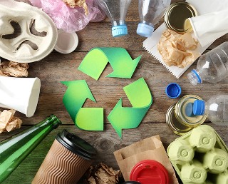 Recycling symbol and different garbage on wooden background, top view